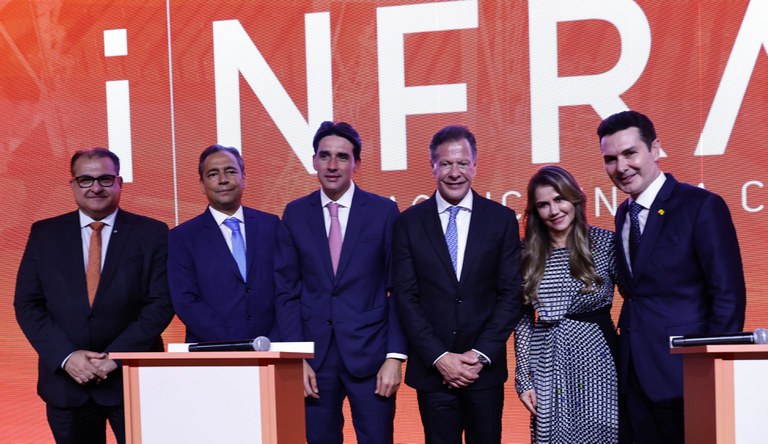 Grupo de pessoas em pé sorrindo.