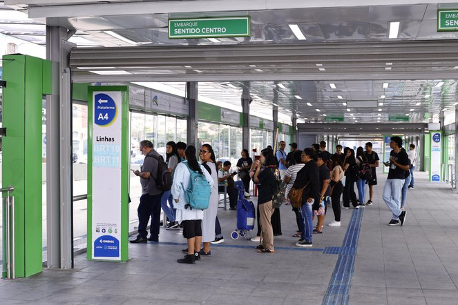 Grupo de pessoas em pé aguardando BRT.
