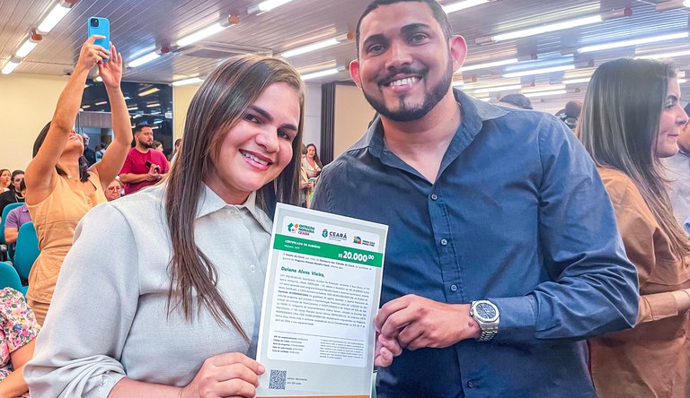 Na imagem casal posa para foto com documento
