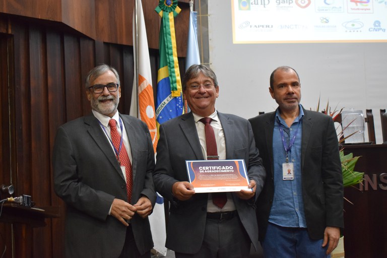 Dr. Renato Cotta (no centro) recebendo o certificado de agradecimento das mãos do reitor do PPGIEN e diretor do IEN, Dr. Cristóvão Araripe (à esquerda), e do coordenador do PPGIEN, Dr. Zelmo Rodrigues (à direita). Foto: Gledson Júnior/IEN/CNEN