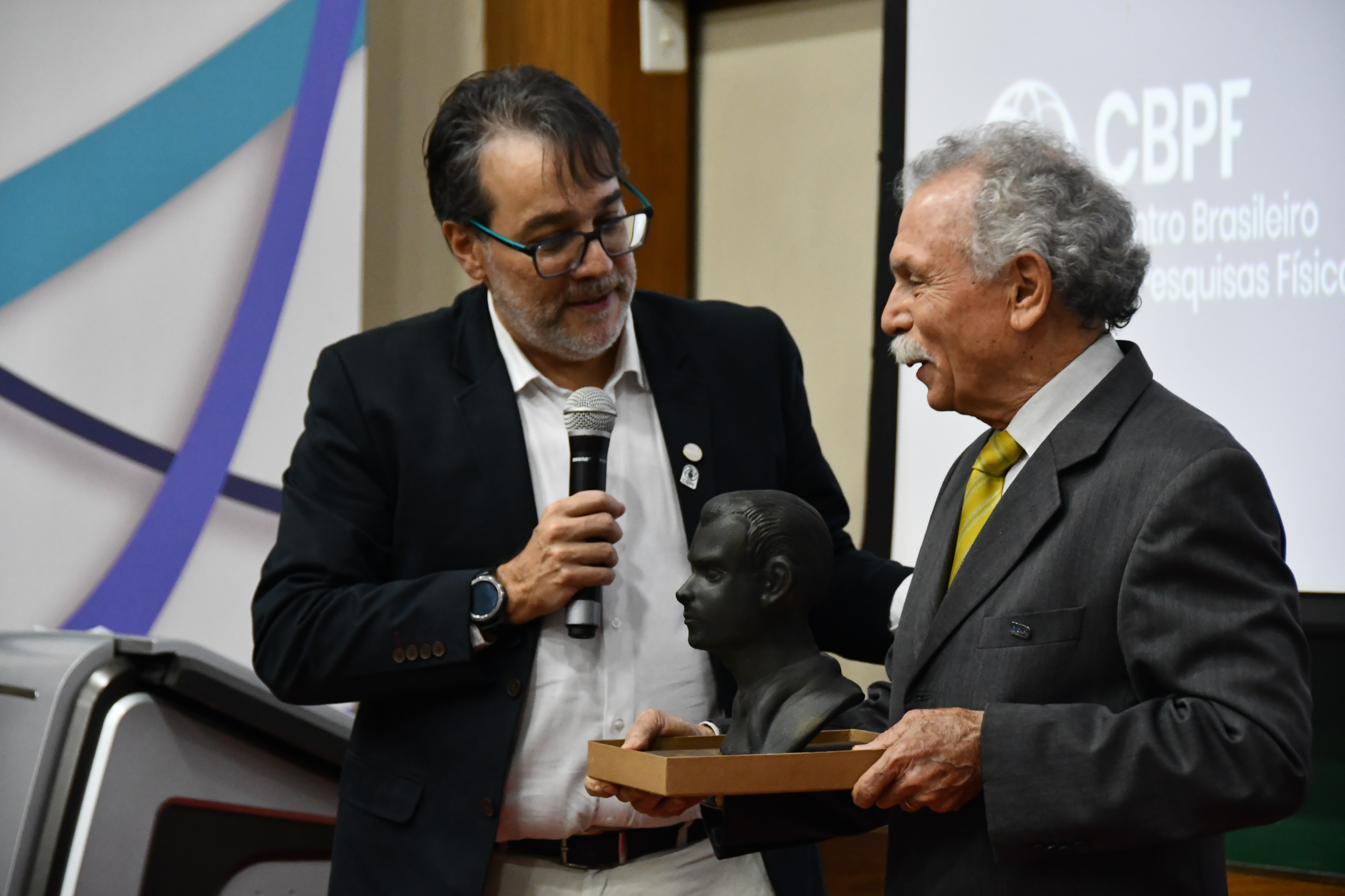O presidente Ricardo Galvão recebe do diretor do CBPF, Márcio Albuquerque, um busto do físico César Lattes confeccionado em impressão 3D no CBPF. Foto: Núcleo de Comunicação do CBPF