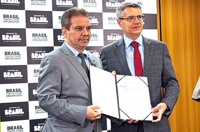 Dois homens de terno com documento assinado.