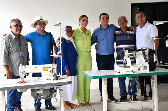 Grupo com máquinas de costura industrial durante entrega de equipamentos.