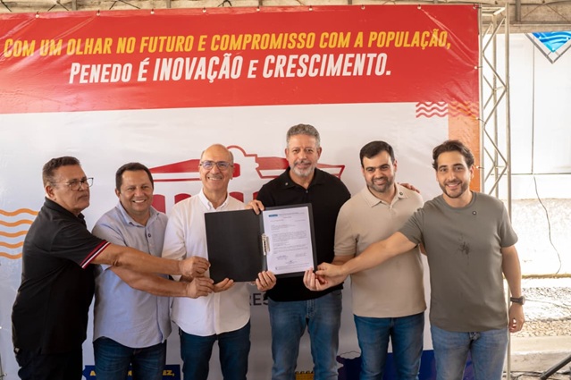 Autoridades exibem documento durante cerimônia de entrega em Penedo, Alagoas.