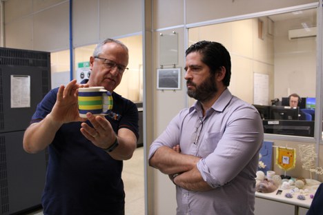 Marcelo Oliveira mostra peça criada com impressora 3D a Eduardo Cruz.