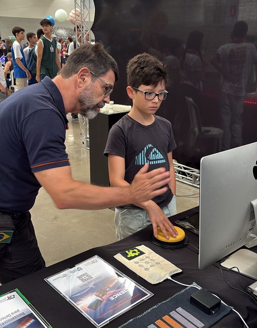 O servidor do CTI Renato Archer Fábio Loyolla apresenta pesquisas da instituição a visitante. 