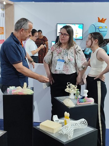 Servidor Marcelo Oliveira mostra peças feitas com modelagem 3D a visitantes.