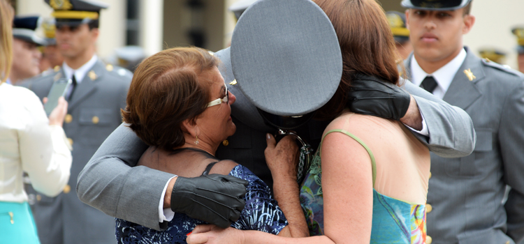 Familiares se emocionam ao entregar a espada aos filhos recém-formados na AMAN: grau de Bacharel em Ciência Militares