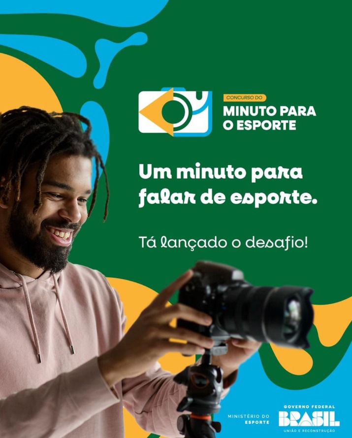 Homem sorrindo segura uma câmera. Fundo verde com formas azuis e amarelas. No topo está o logo do concurso Minuto para o Esporte. Texto: Um minuto para falar de esporte. Tá lançado o desafio! Logos do Ministério do Esporte e Governo Federal.