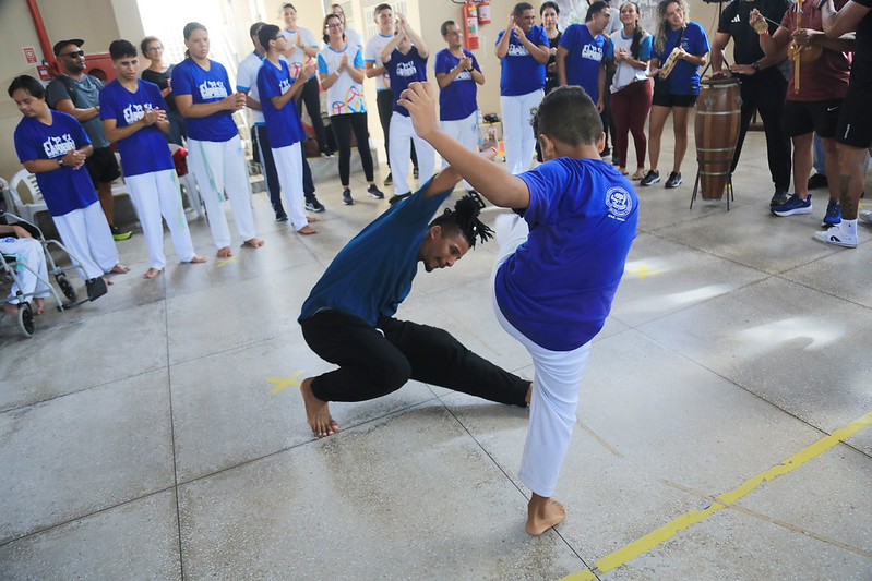 Professor e estudante do TEAtivo lutando capoeira
