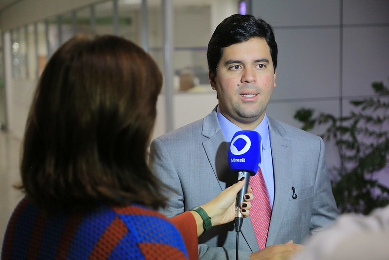 Ministro André Fufuca dá entrevista a repórter que está de costas.