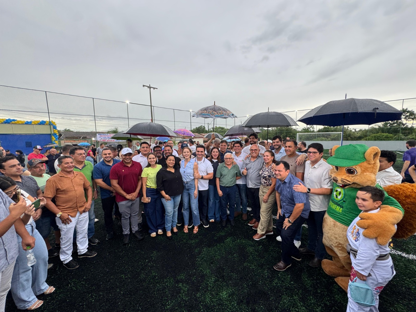 Todos posam para foto dentro do campo da Arena Brasil.