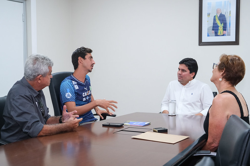 Estão sentados à mesas o atleta Caio Bonfim, ao lado do pai e da mãe e do ministro André Fufuca.