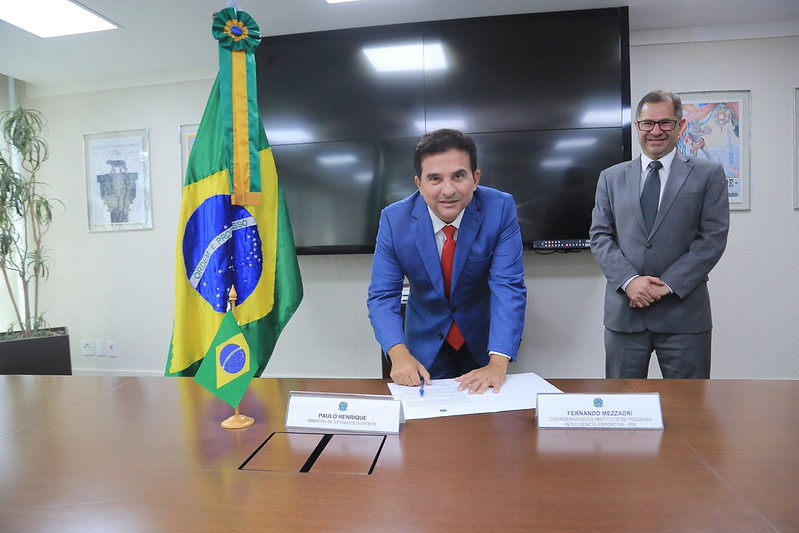 Ministro assinando documento.