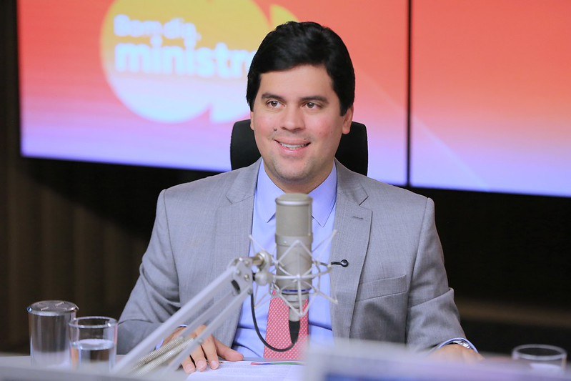Ministro André Fufuca de terno cinza sorri para a foto.