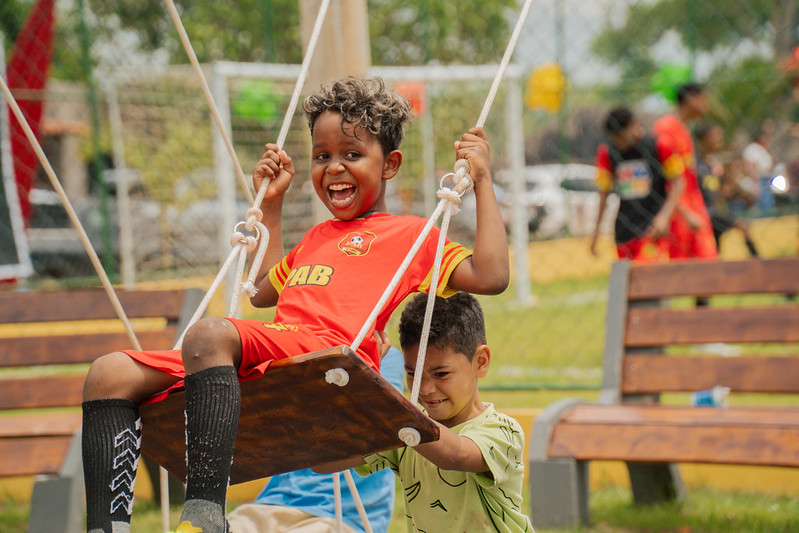 Criança no balanço da arena brasil