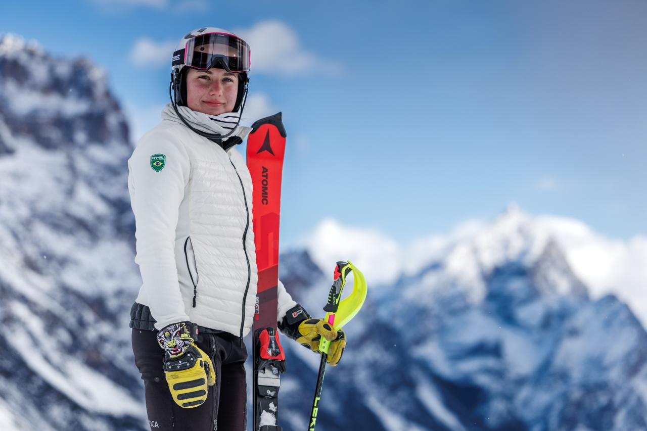 Atleta posa para a câmera segurando o esqui.