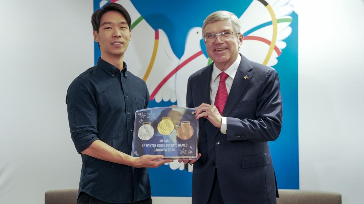 Dante Uwai recebe as medalhas de ouro, prata e bronze que desenhou das mãos do presidente do COI, Thomas Bach. Foto: Marina Ziehe/COB