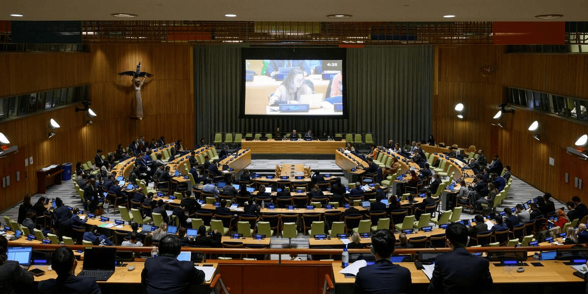 Plenário da ONU com delegados reunidos em sessão, diante de telão central iluminado