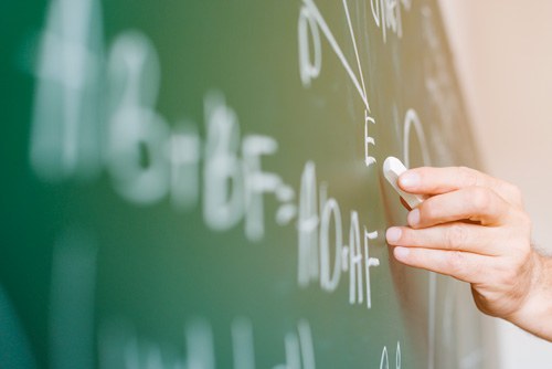 aged-math-teacher-writing-formula-chalkboard-(1).jpg