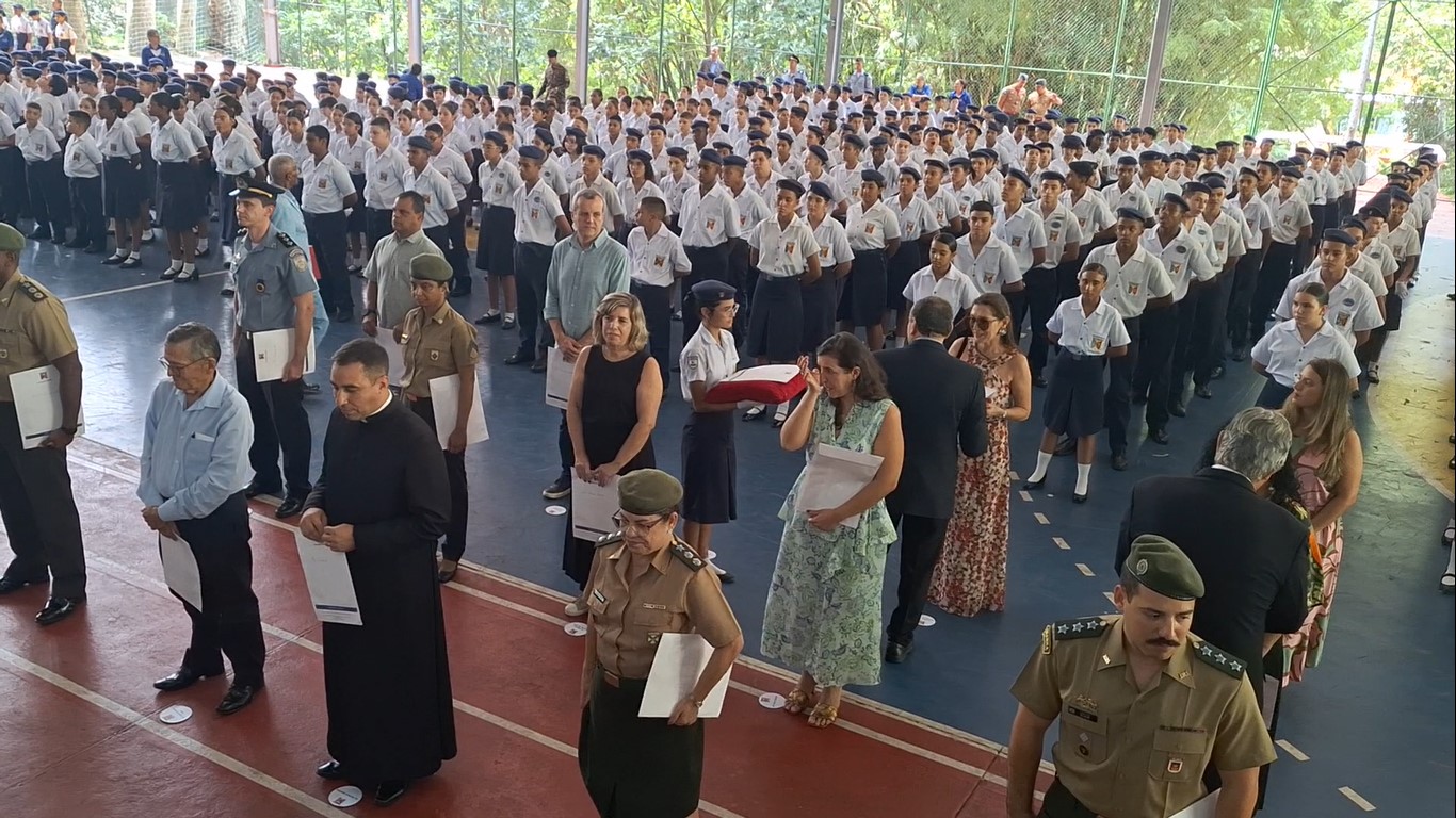 Alunos uniformizados participam de formação em cerimônia cívico-militar escolar.