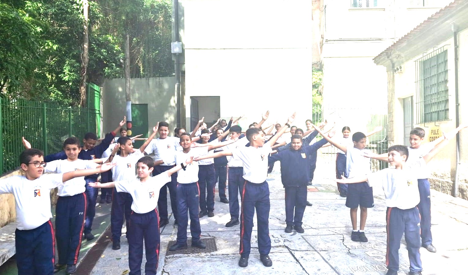 Estudantes formam ângulos agudos, retos e obtusos com os braços durante aula.