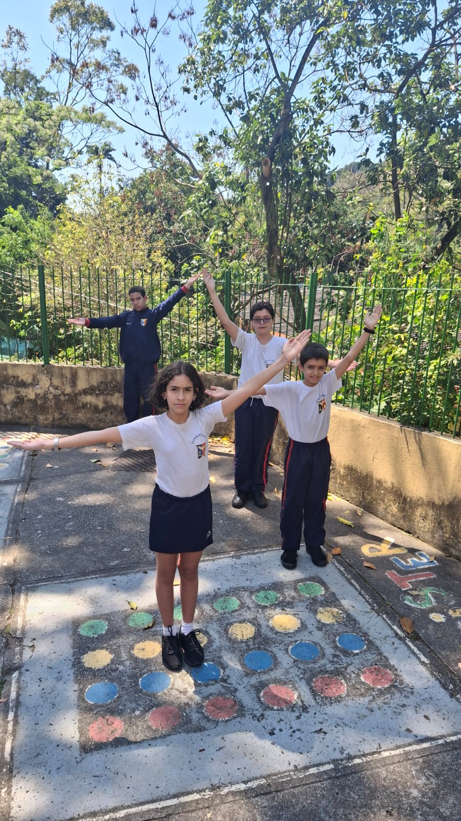 Alunos do 5º ano formam ângulos com os braços em atividade de matemática.