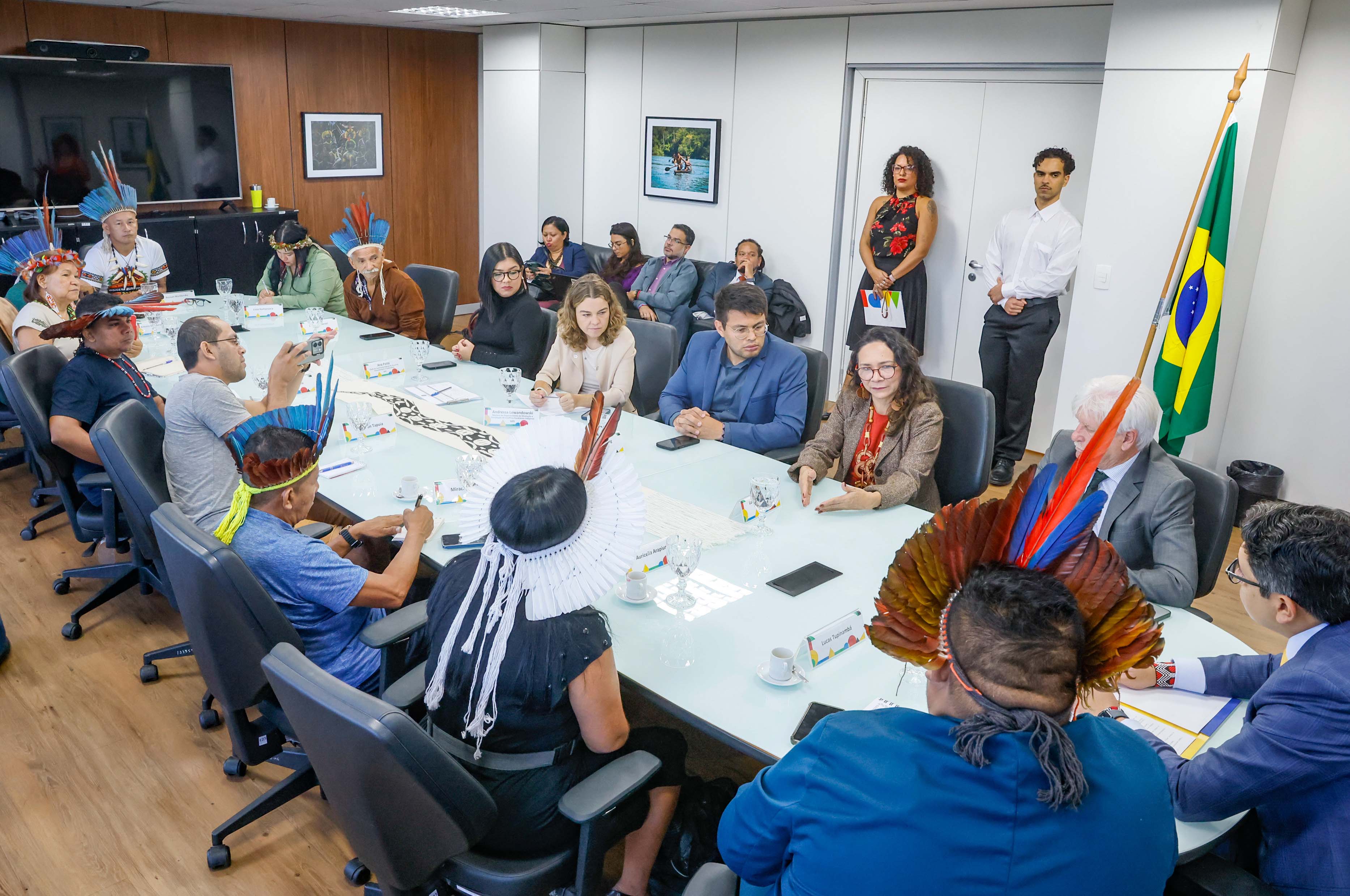 Ministro do MPI, Presidenta da Funai e outros indígenas em uma mesa de reunião