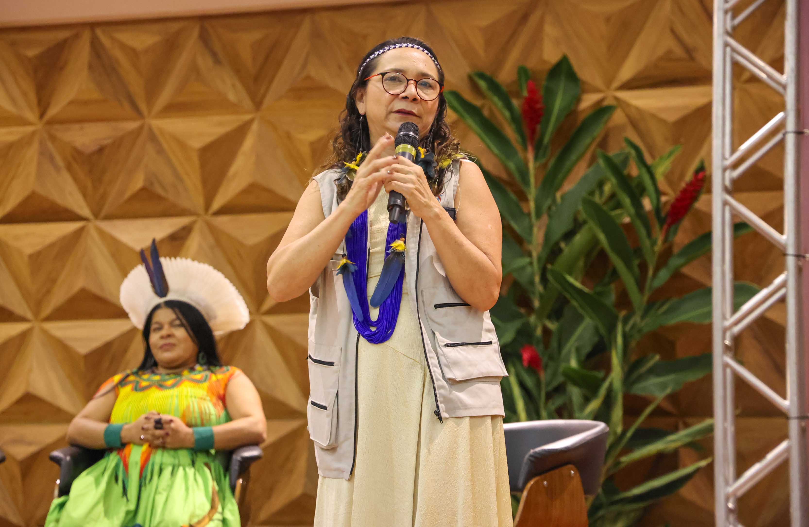 presidenta no palco com microfone palestrando