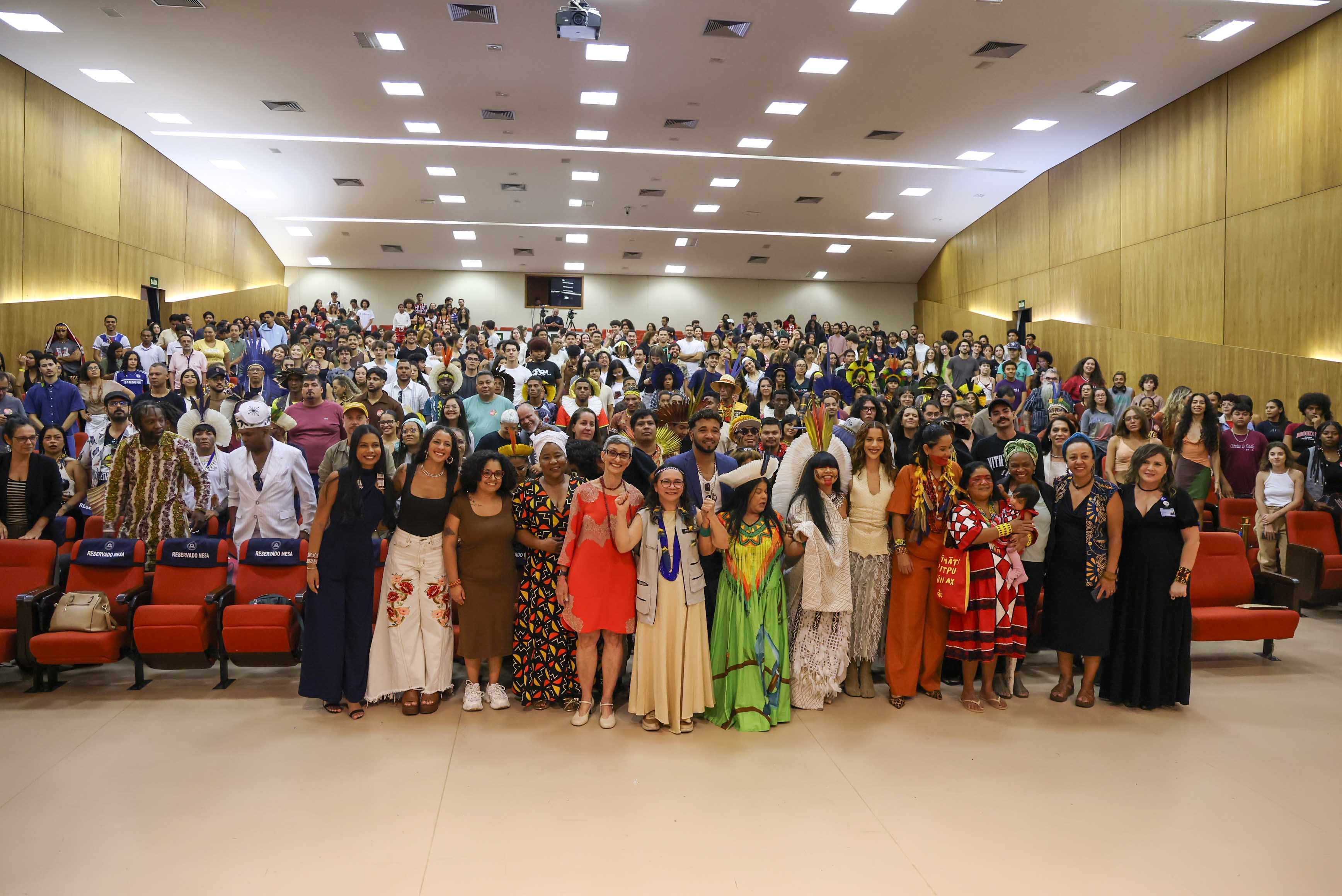 Muitos participantes do evento em pé posando para foto
