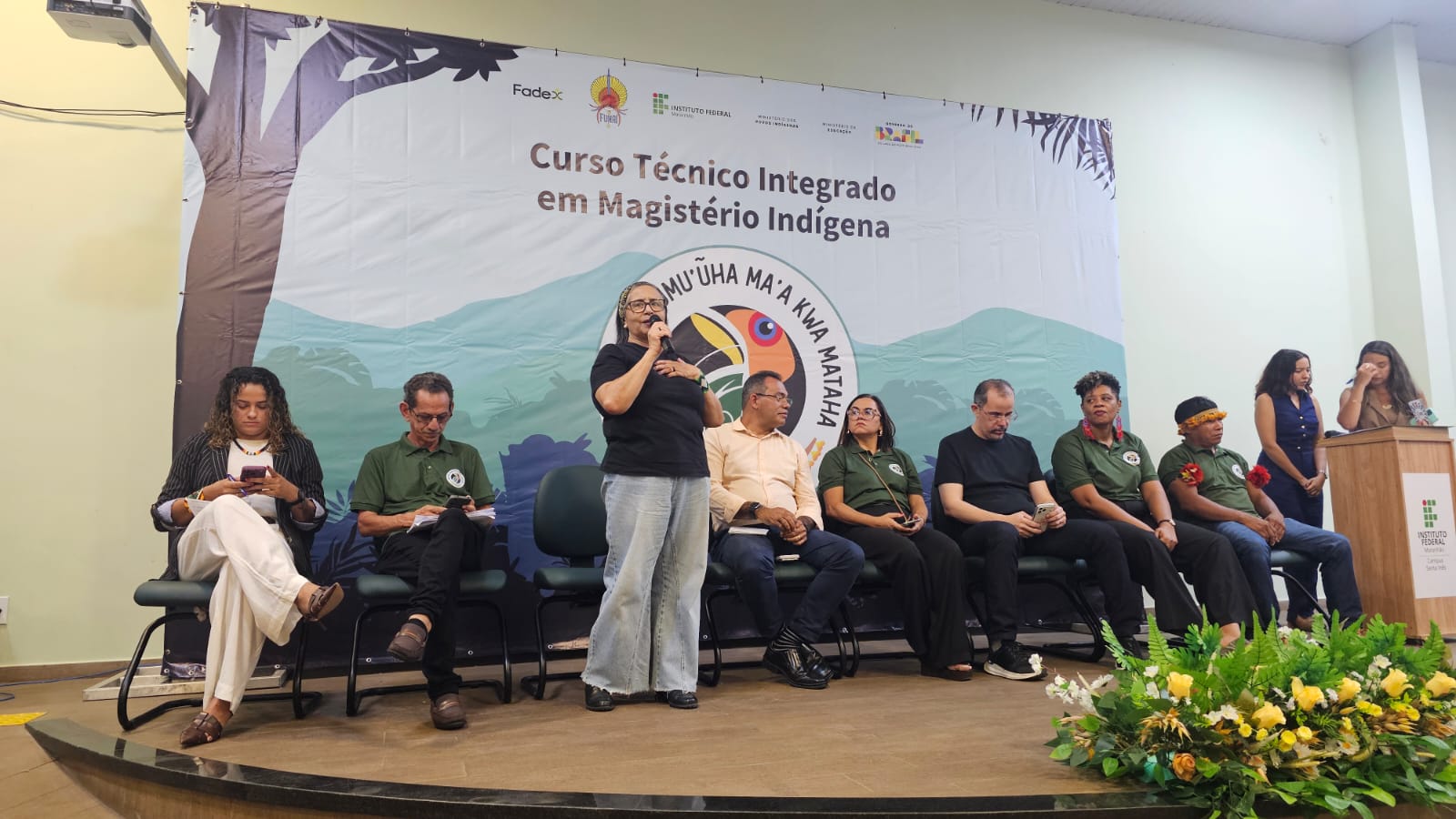 Dispositivo de autoridades com servidora da Funai em pé fazendo a fala pela Funai