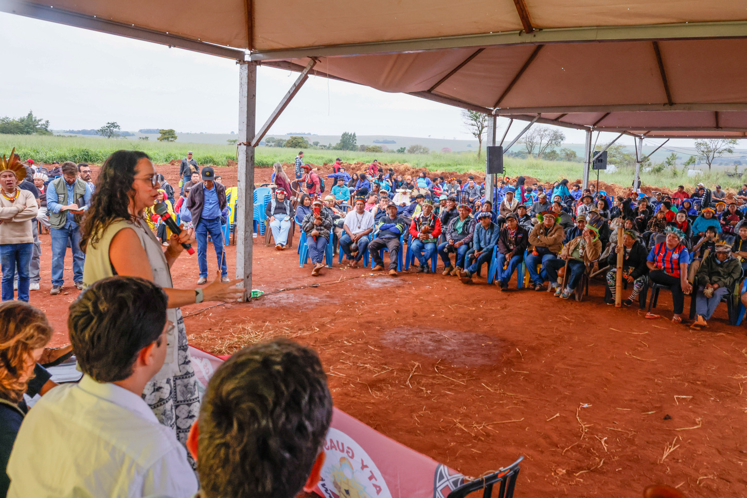 Presidenta da Funai falando no palco e diversas pessoas na plateia