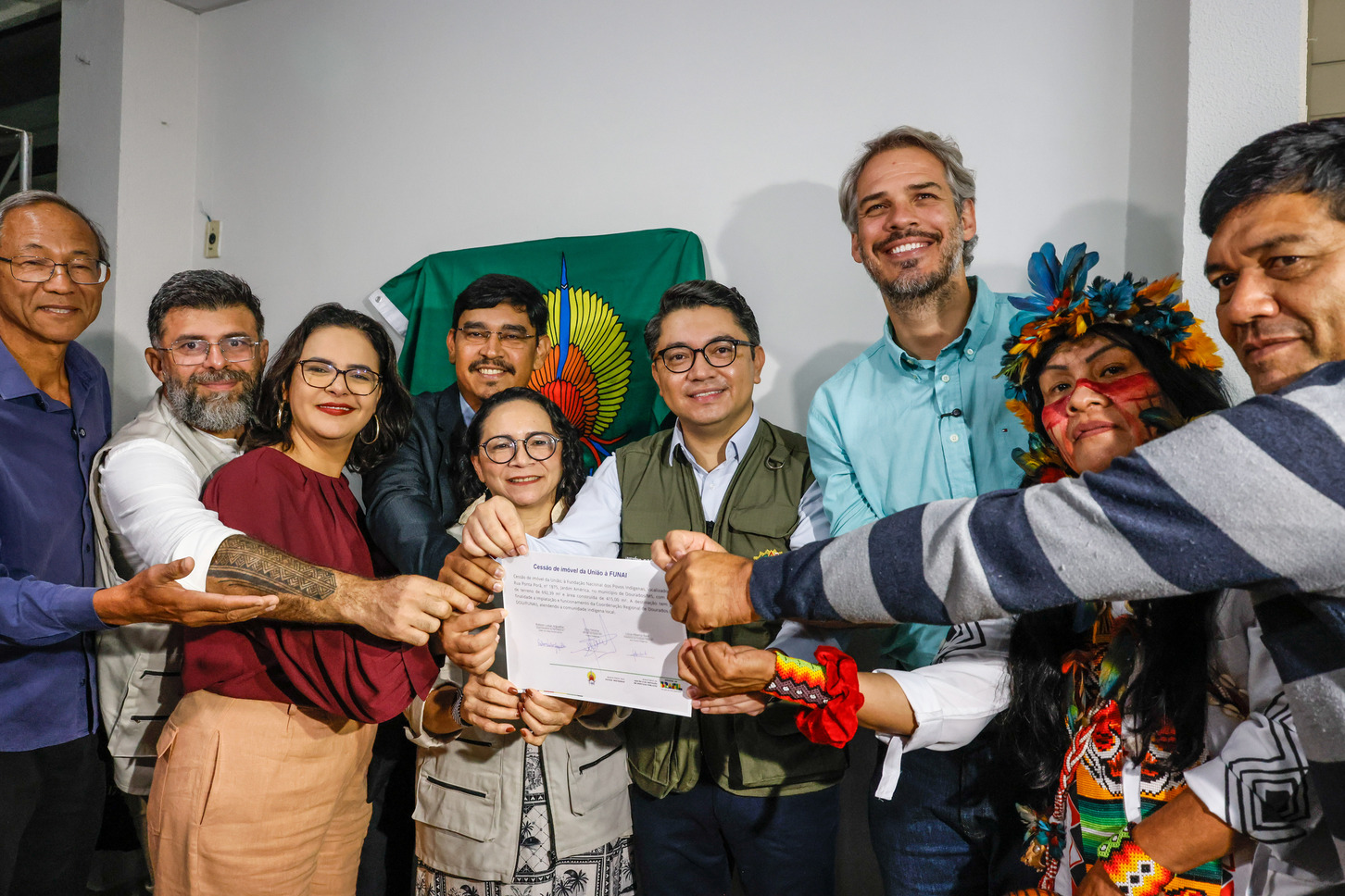 Diversas pessoas segurando um documento assinado
