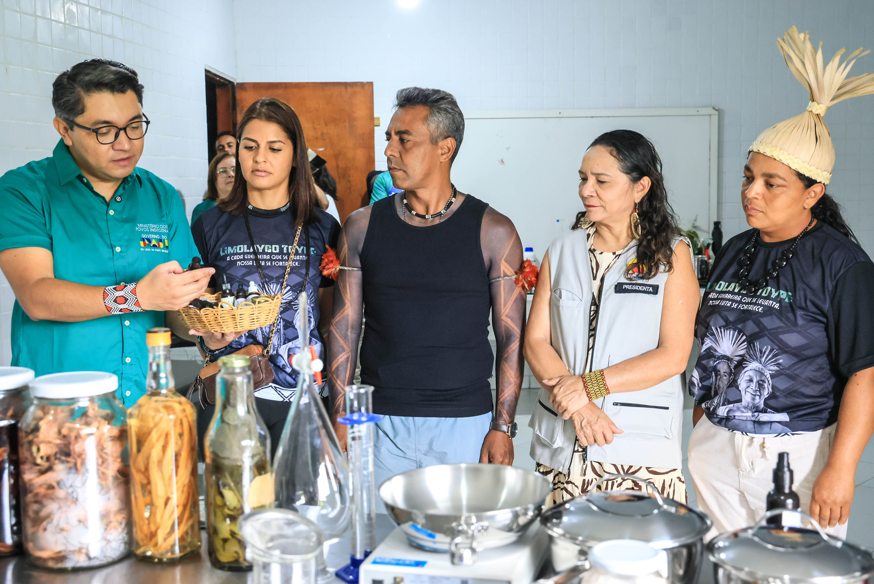 Eloy Terena analisa um dos frascos de vidro retirado de uma cesta de palha contendo outros iguais