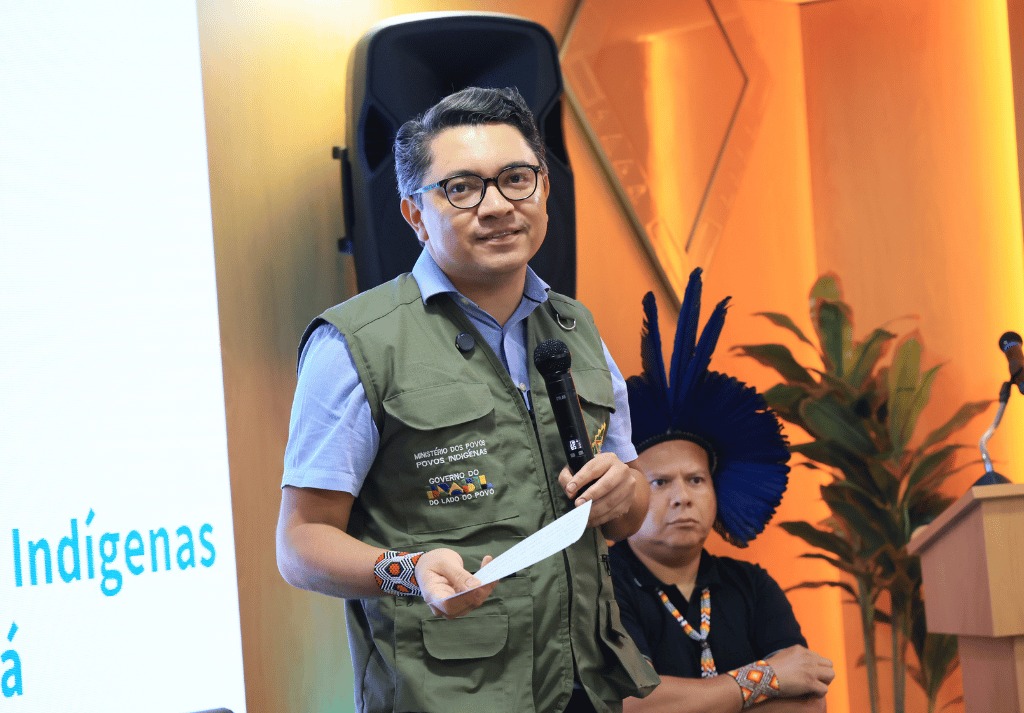 ministro do MPI com microfone e papel na mão