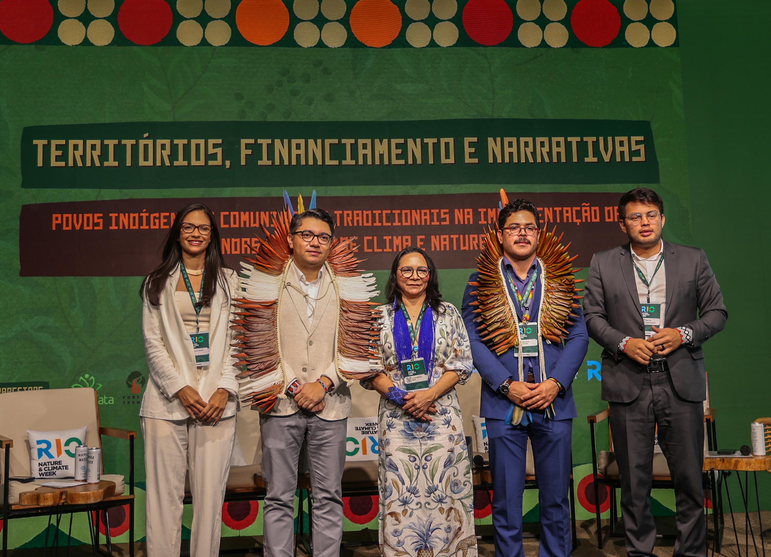 3 homens e 2 mulheres em cima de um palco posando para foto