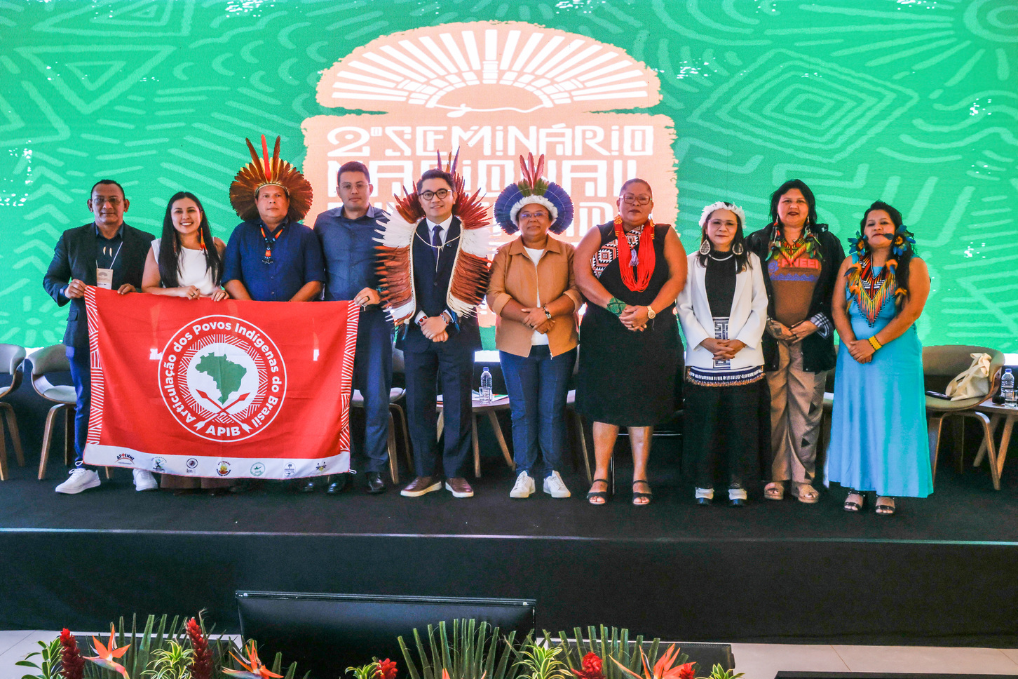 Lideranças indígenas posam no palco do seminário