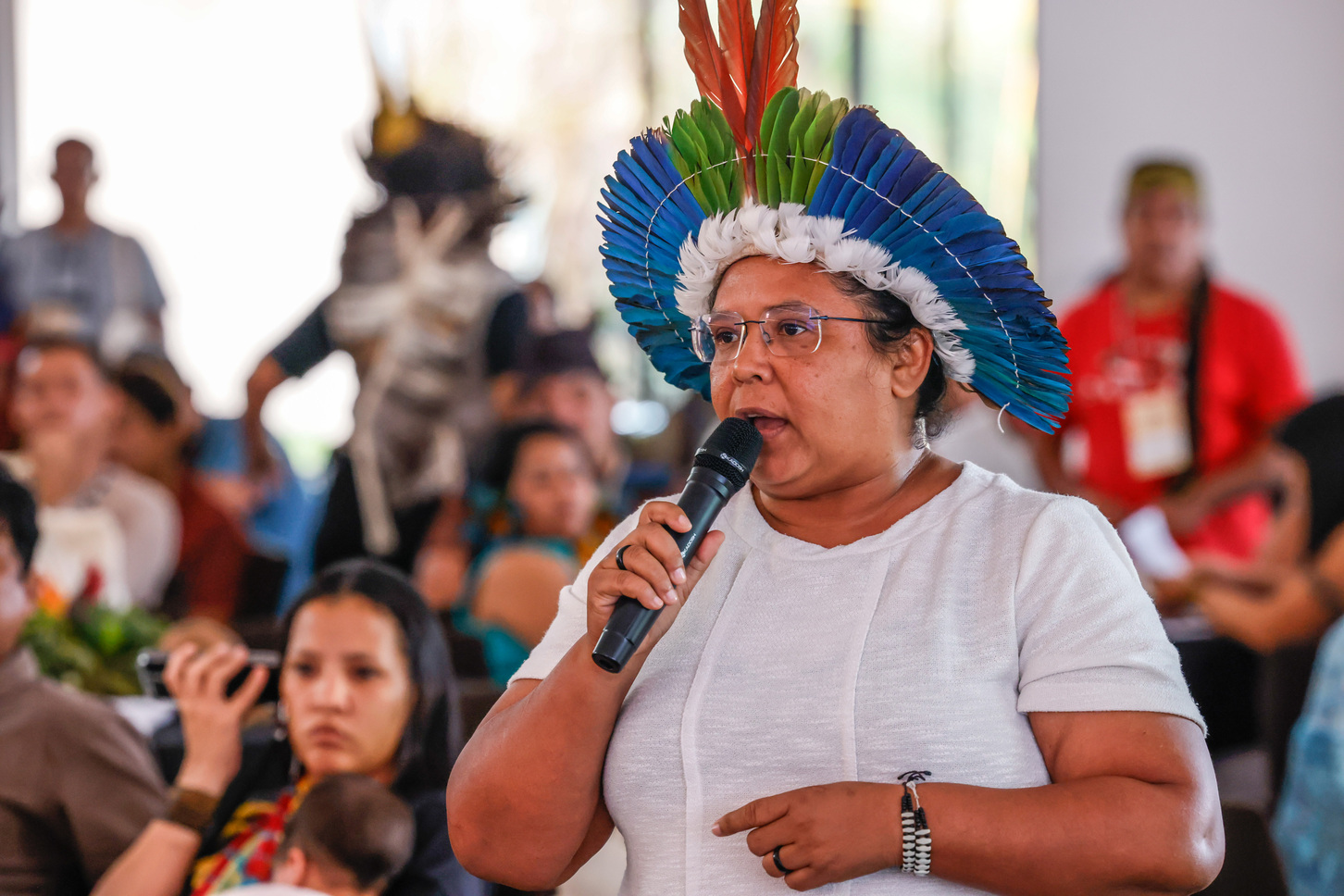 Representante indígena de órgão indigenista fala ao microfone durante seminário