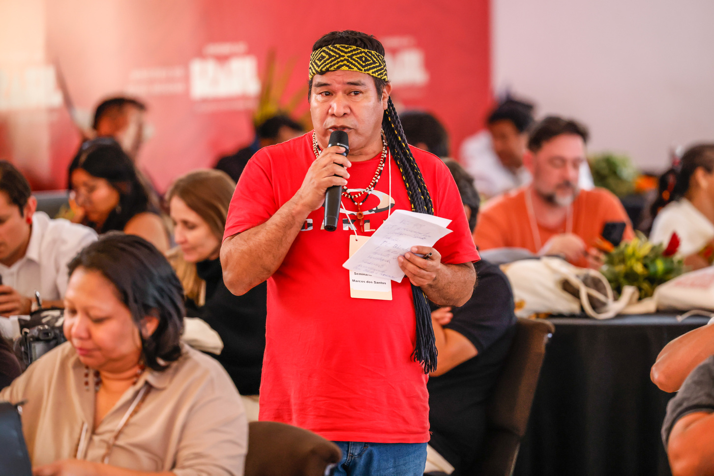 Liderança indígena fala ao microfone durante seminário