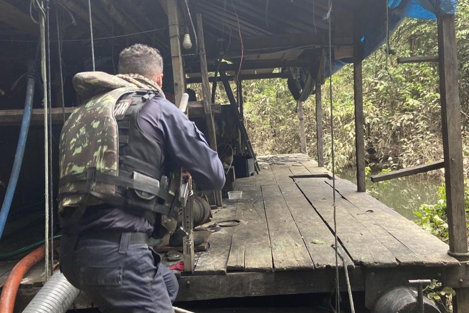 Homem de fiscalização se preparando pra entrar em casa de garimpo