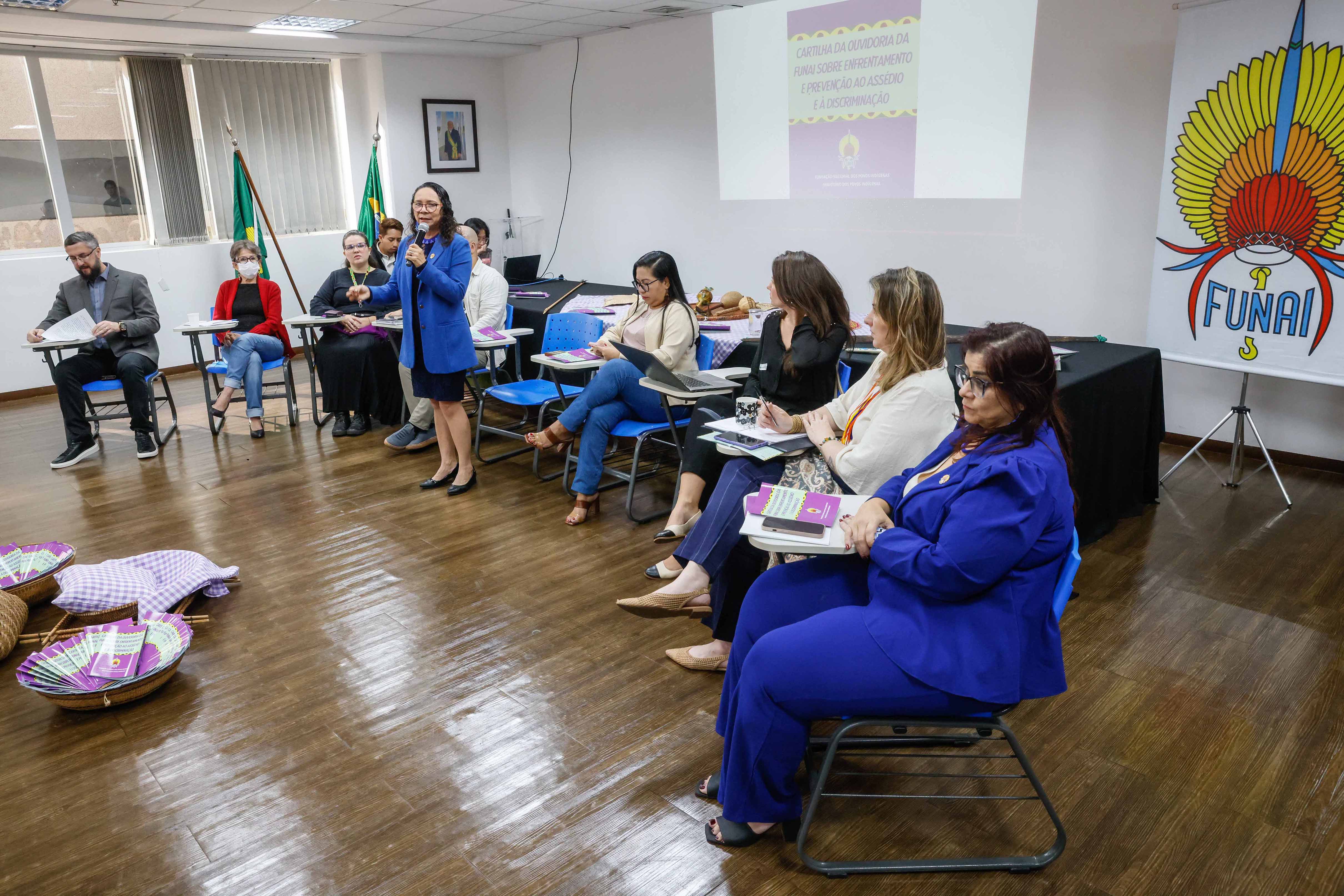 Presidenta da Funai discursa durante evento no centro de um semi-círculo composto por servidores