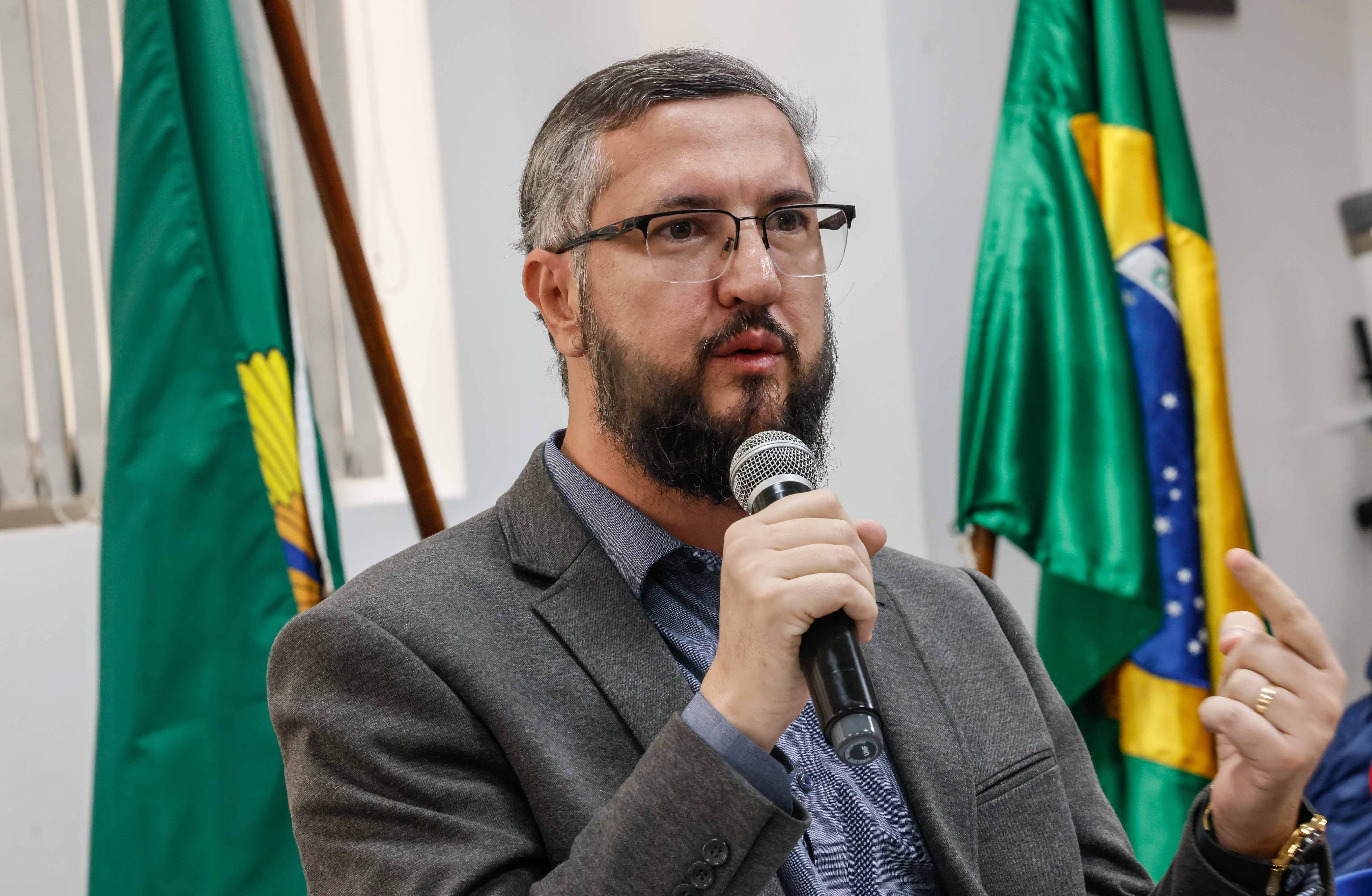 Representante da Corregedoria da Funai discursa em evento, segura um microfone e gesticula.