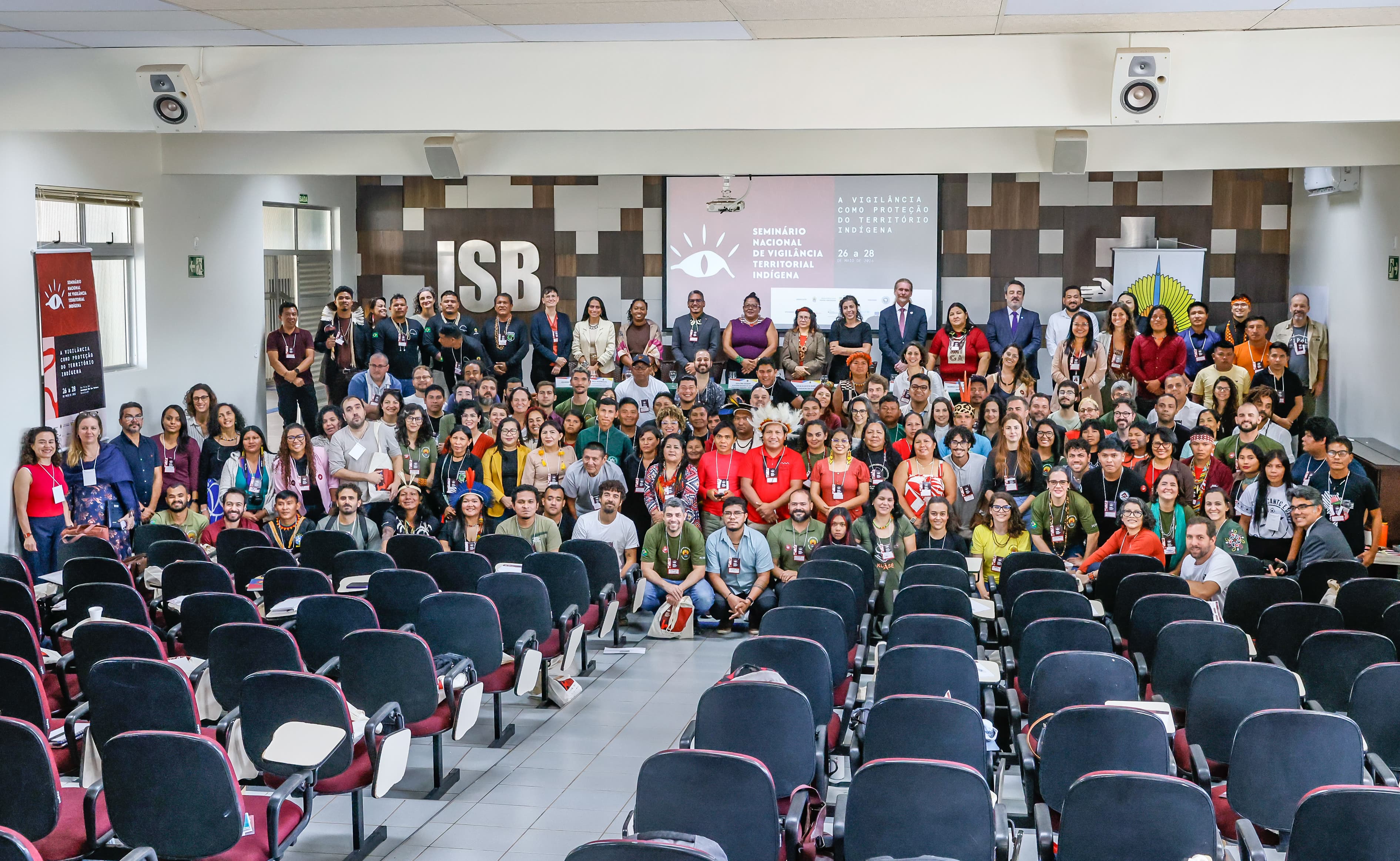 Foto oficial do evento, com muitas pessoas na frente do palco posando pra foto