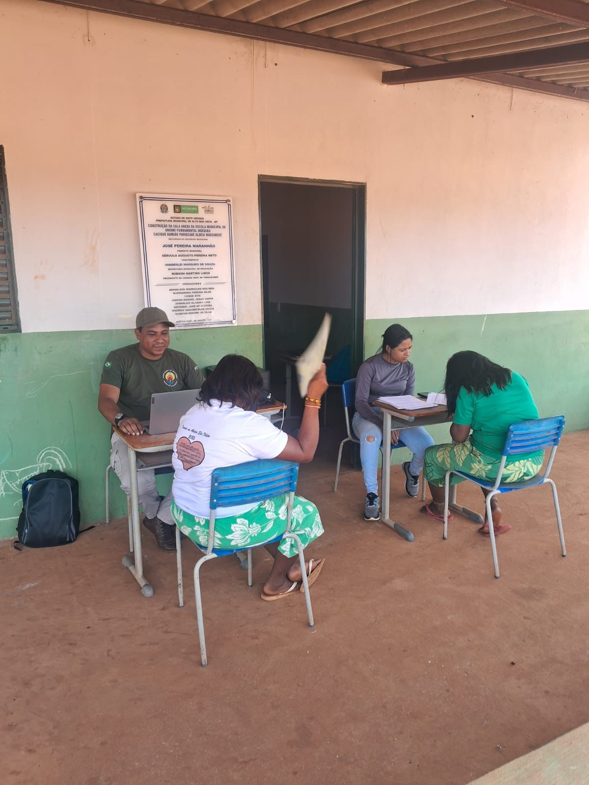 Duas mulheres indígenas recebem atendimento de dois servidores da Funai