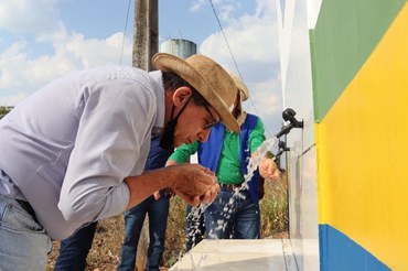 Representante da prefeitura bebendo água após a entregaFoto: Prefeitura de Presidente Médici