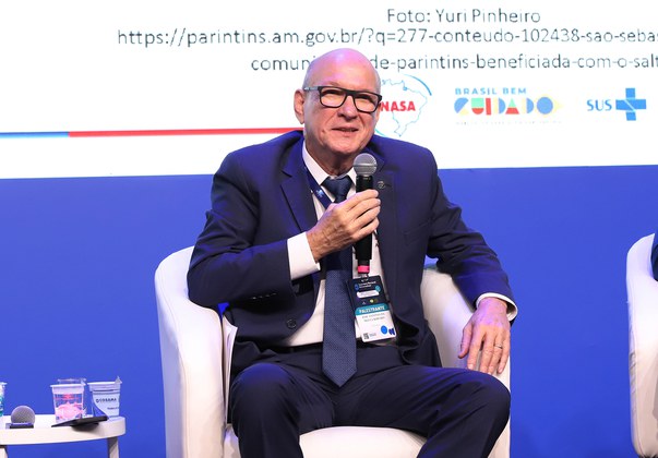 Homem sentado com um microfone na mão