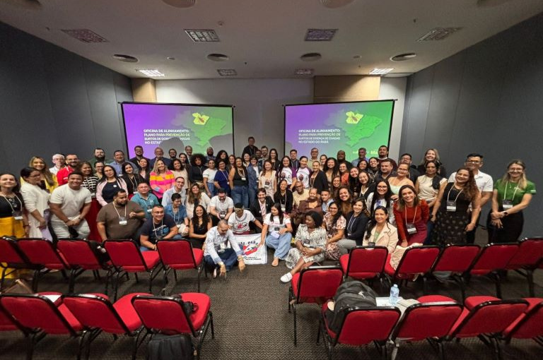Grupo de dezenas de pessoas posa para foto em auditório com dois telões ao fundo sobre prevenção da doença de Chagas no Pará.