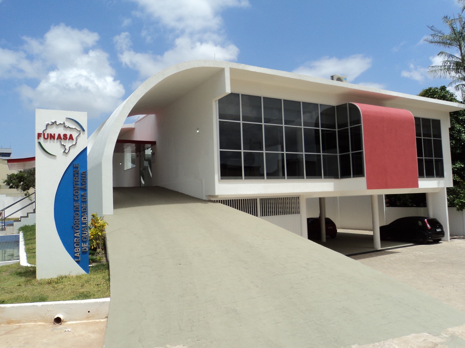 Prédio do laboratório da Funasa, com fachada moderna, rampa de acesso e placa institucional, destinado ao controle da qualidade da água.