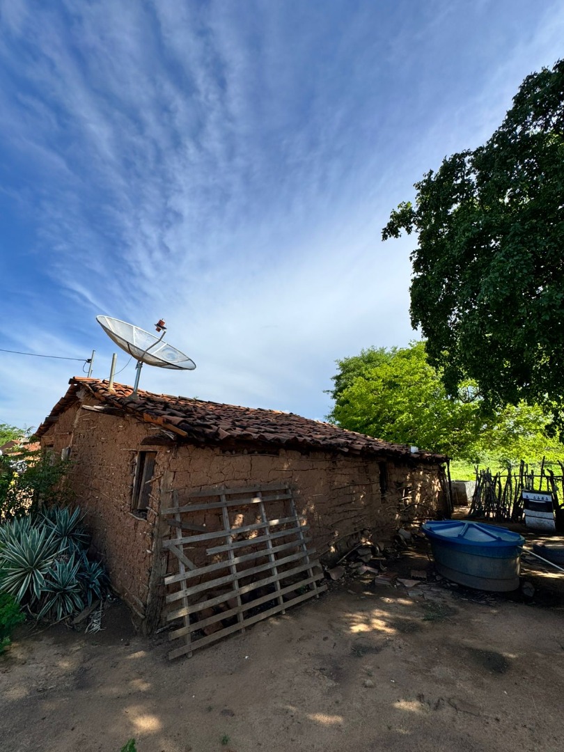 Casa de taipa com telhado de barro, antena parabólica e vegetação ao redor, sob céu azul com nuvens. - Foto_ Suest-PB_Funasa.jpeg
