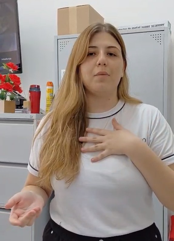 Retrato de uma jovem estudante de uniforme branco e cabelos loiros.